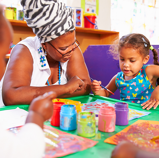 Early Childhood Education Preschool teacher teaching basic skills such as colors and shapes to little girl