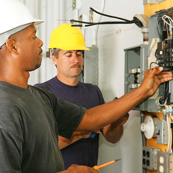 Electrician helper trace out short circuits in wiring, using test meter.