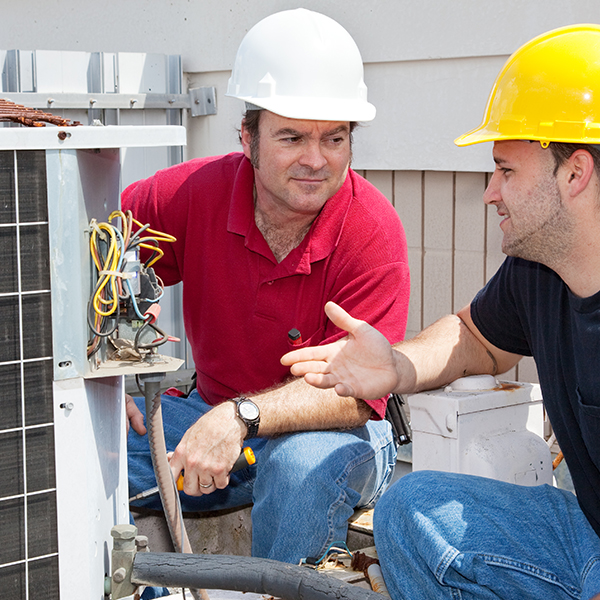 Residential HVAC technician training his HVAC helper 